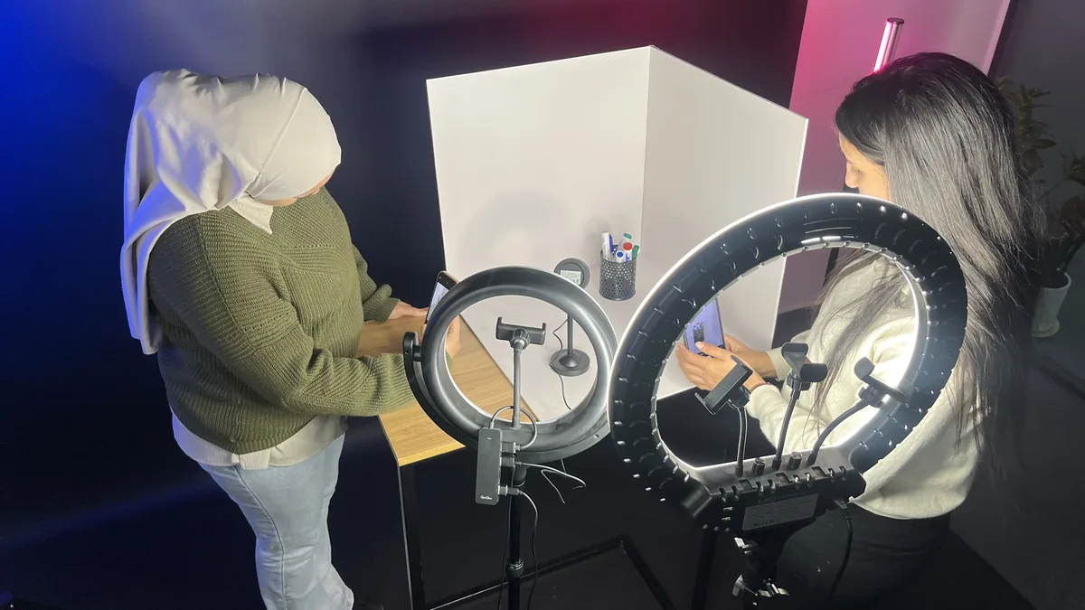 Deux participantes filment un produit au smartphone avec des ring lights pendant un atelier de création de contenu
