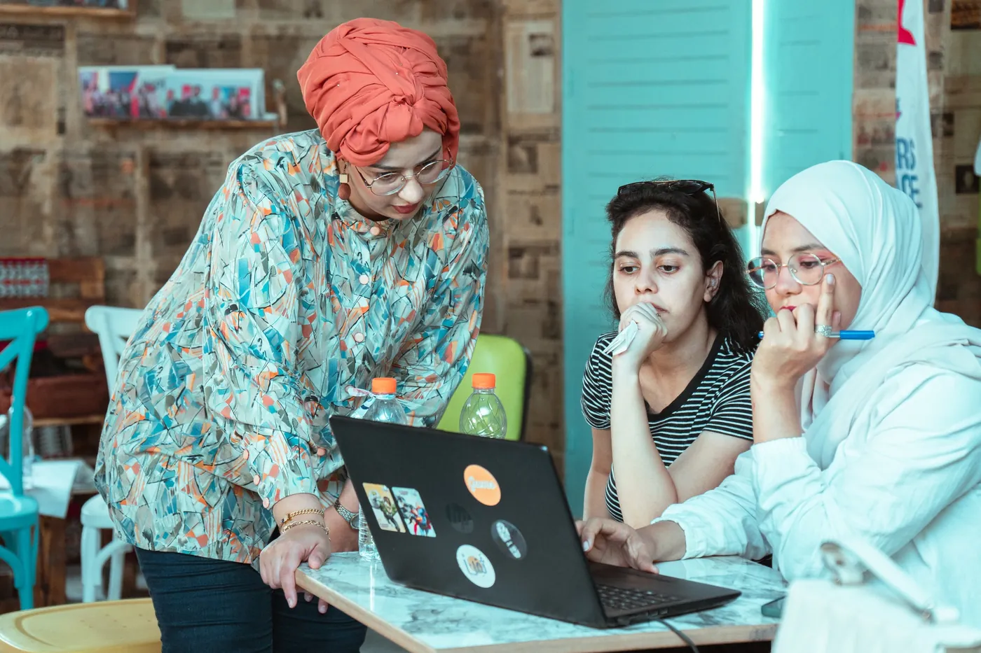Mariam Ben Aissa accompagnant deux participantes sur leur ordinateur pendant une formation