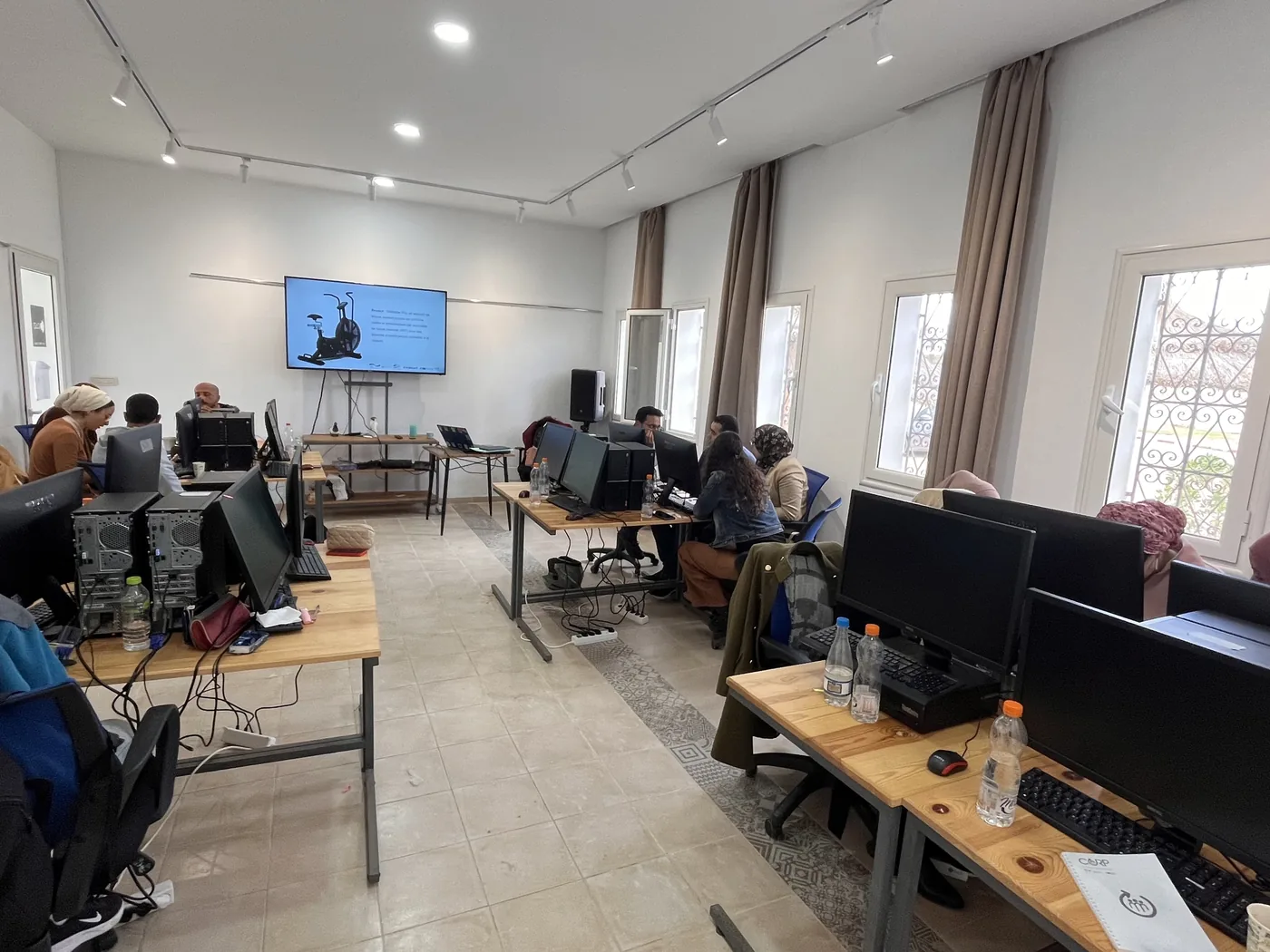 Salle de formation équipée en Tunisie, participants sur ordinateur pendant un atelier