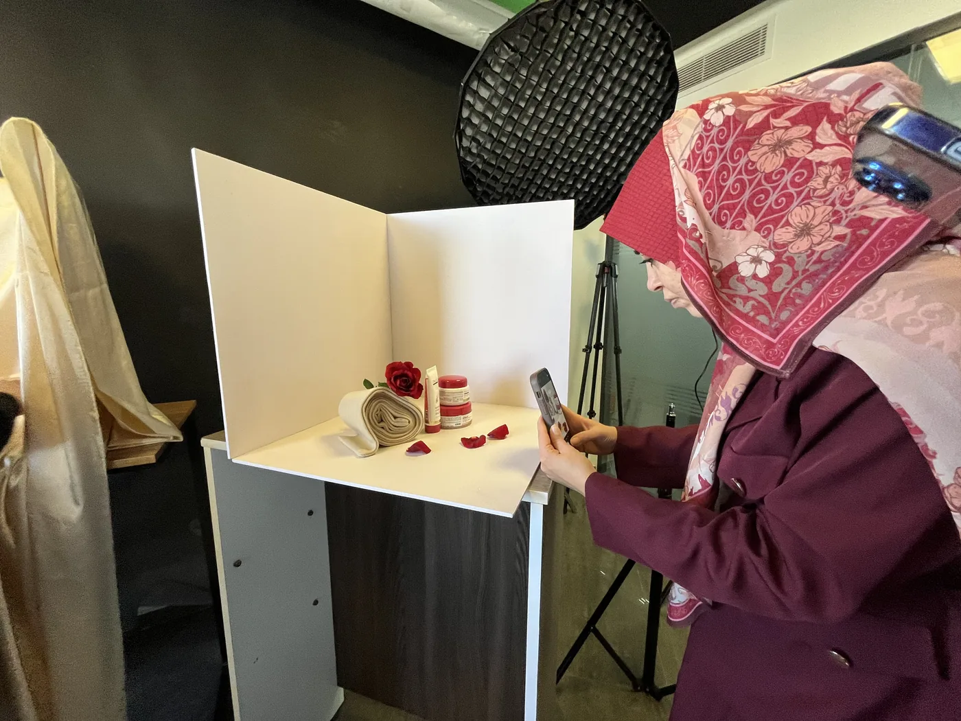 مشاركة تصوّر منتجاتها بالهاتف في ستوديو صغير خلال الجلسة